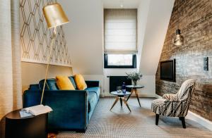 a living room with a blue couch and a chair at Hotel am Ochsentor in Andernach