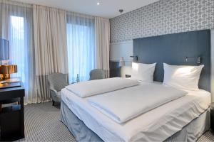 a bedroom with a large bed with a blue headboard at Hotel am Ochsentor in Andernach