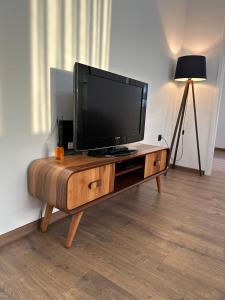 una TV a schermo piatto seduta sopra un tavolo di legno di Kula apartman - Novi Pazar a Novi Pazar