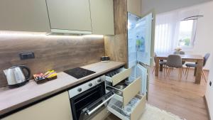 una cucina con piano cottura forno superiore accanto a un tavolo di Kula apartman - Novi Pazar a Novi Pazar