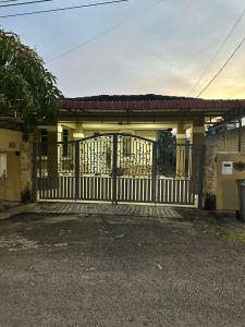 a garage with a gate and a building at ROSHUS HOMESTAY MELAKA in Ayer Keroh