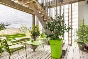 einen Balkon mit grünen Bänken und Topfpflanzen in der Unterkunft Location chambre privée avec salle de bain et WC privatifs dans appartement moderne in Nantes