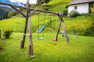 um parque infantil com baloiços num campo de relva em Brennergut Ferienwohnung am Bauernhof em Mühlbach am Hochkönig