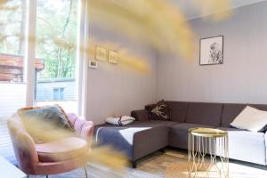 a living room with a couch and a chair at Heerlijk Huisje Hoenderloo in Hoenderloo