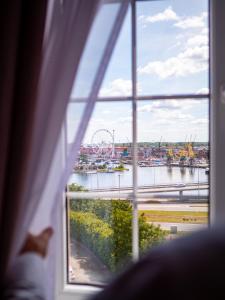 una finestra con vista su un fiume e su una ruota panoramica di Focus Hotel Szczecin a Stettino