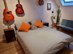 Schlafzimmer mit einem Bett mit Gitarren an der Wand in der Unterkunft Minus is Joenus in Ostende