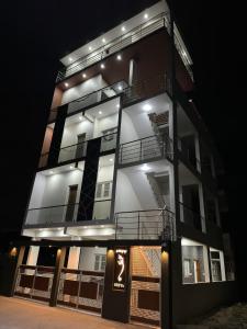 un palazzo alto con luci accese di notte di DEEYA Guest House - A Luxury Home Stay a Mysore