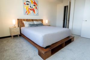 a bedroom with a bed and two lamps on tables at Luxury Apartment West Hollywood in Los Angeles