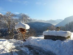 un cumulo di neve in cima a una casetta per uccelli di Gästehaus Obersulzberglehen a Schönau am Königssee