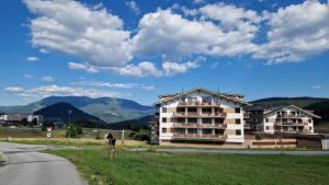 ein Gebäude an der Seite einer Straße mit Bergen in der Unterkunft Apartment Panorama 35C in Donovaly