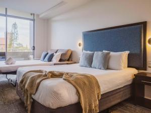 Mercure Centro Port Macquarie tesisinde bir odada yatak veya yataklar