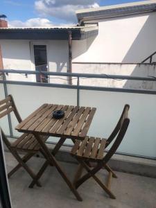 una mesa de madera y una silla en el balcón en Moderne Neue 2 Zimmer Wohnung, en Uetersen