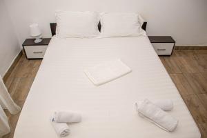 uma grande cama branca com duas almofadas em Occidental Wise Transit Hotel em Bucareste