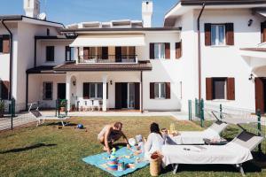 a man and a woman sitting on a blanket in the grass at Anima Jesolo - Ca' delle Rose in Lido di Jesolo