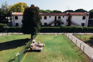 two people are sitting on a couch in the grass at Anima Jesolo - Ca' delle Rose in Lido di Jesolo