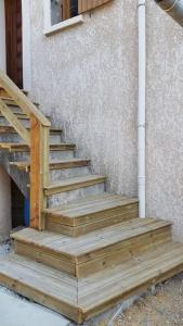 un escalier en bois à côté d'un bâtiment dans l'établissement Studio climatisé avec terrasse, fibre et Wi FI ., à Saint-Marcel-lès-Valence