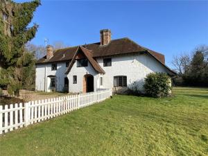 une maison blanche avec une clôture blanche dans l'établissement Chichester Retreat with Large Private Mature Garden, à Chichester