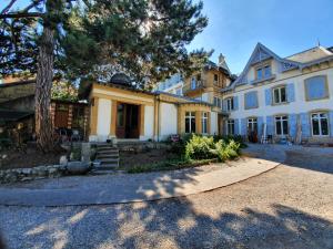 una gran casa blanca con un árbol en Le Faubourg 29, en Neuchâtel