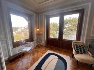 sala de estar con 2 ventanas grandes y una silla en Le Faubourg 29, en Neuchâtel