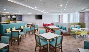 a waiting room with tables and chairs at Hampton Inn By Hilton Hamilton in Hamilton