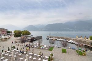 un grande bacino d’acqua con un gruppo di tavoli e sedie di Greta House a Colico