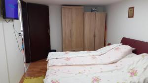 1 dormitorio con 2 camas con sábanas y armario en Berta Apartman, en Senta