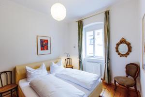 1 dormitorio con 1 cama con sábanas blancas y ventana en Stadthaus Mariazell, en Mariazell