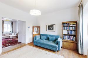 sala de estar con sofá azul y estante para libros en Stadthaus Mariazell, en Mariazell