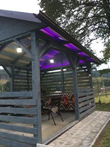 une pergola avec éclairage violet sur une terrasse dans l'établissement U Ilka, à Lazeshchyna