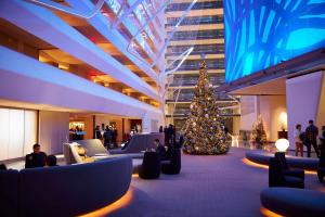 een kerstboom in het midden van een lobby met mensen bij Conrad New York Downtown in New York