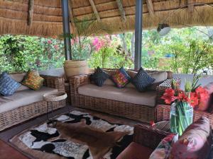 ein Wohnzimmer mit Sofas und einem Teppich in der Unterkunft Sunbirds Chobe Hotel in Kasane