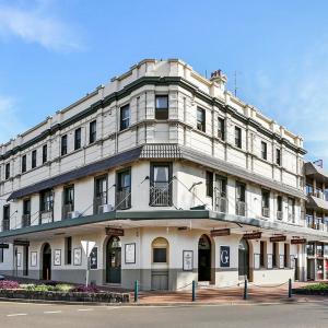 een groot wit gebouw in een stadsstraat bij Beachside Budget Rooms in Kiama