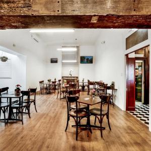 een restaurant met tafels en stoelen in een kamer bij Beachside Budget Rooms in Kiama