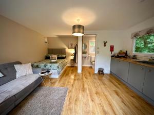 a large living room with a couch and a kitchen at Highland HotTub Retreat, on NC500 in Inverness