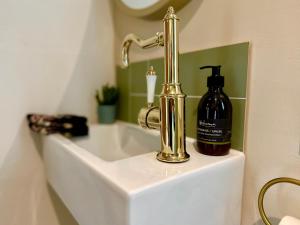 a bathroom sink with a bottle of soap on it at Highland HotTub Retreat, on NC500 in Inverness