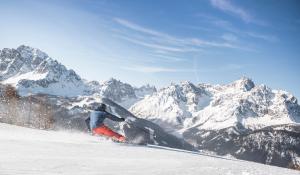 une personne faisant du snowboard sur une montagne enneigée dans l'établissement Post Hotel - Tradition & Lifestyle Adults Only, à San Candido