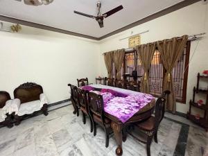 comedor con mesa, sillas y techo en SAN HOME STAY, en Mysore