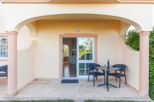 une terrasse avec une table et des chaises devant une maison dans l'établissement Atalaia Sol Aparthotel - tennis & heated pool in winter, à Lagos