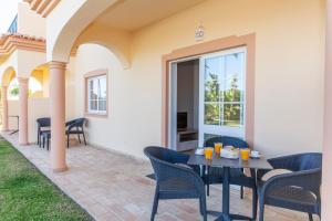 une terrasse avec des chaises et une table avec de la nourriture. dans l'établissement Atalaia Sol Aparthotel - tennis & heated pool in winter, à Lagos