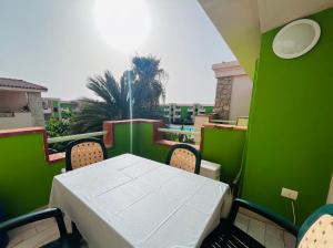 Cozy Apartment with Pool, near Beach and Center في سانتا ماريا: طاولة وكراسي على شرفة مع جدار أخضر