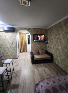 a living room with a couch and a tv on the wall at gabro in Mtskheta