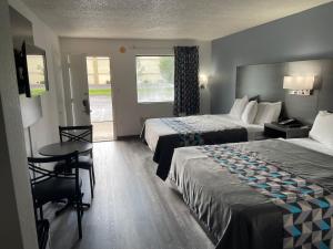 Habitación de hotel con 2 camas y mesa en American Inn - Paducah, en Paducah