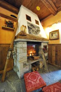 un soggiorno con camino in pietra in una casa di L'Ancien Paquier Chambre D'Hotes a Valtournenche