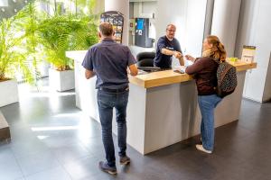 a man and a woman standing at a counter at Hostel Van Gogh in Brussels