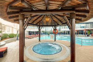 una gran piscina con un gran techo de madera en Copthorne Hotel Dubai, en Dubái