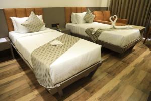 um quarto de hotel com duas camas num quarto em Krown Palace Resort em Silvassa