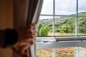 ventana con vistas a la montaña en Tŷ Afon - River House, en Beddgelert