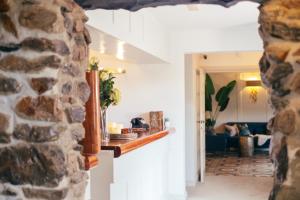 vistas a una sala de estar con una pared de piedra en Tŷ Afon - River House, en Beddgelert