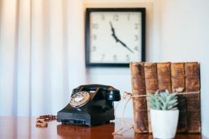 un reloj y un teléfono en una mesa con una planta en Tŷ Afon - River House, en Beddgelert