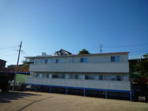 Seaside Hostel Light House - Vacation STAY 82325v في أونوميتشي: عمارة سكنية فوقها سقف